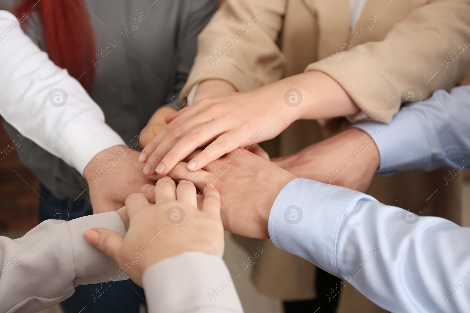 Photo of Group of people holding their hands together, closeup