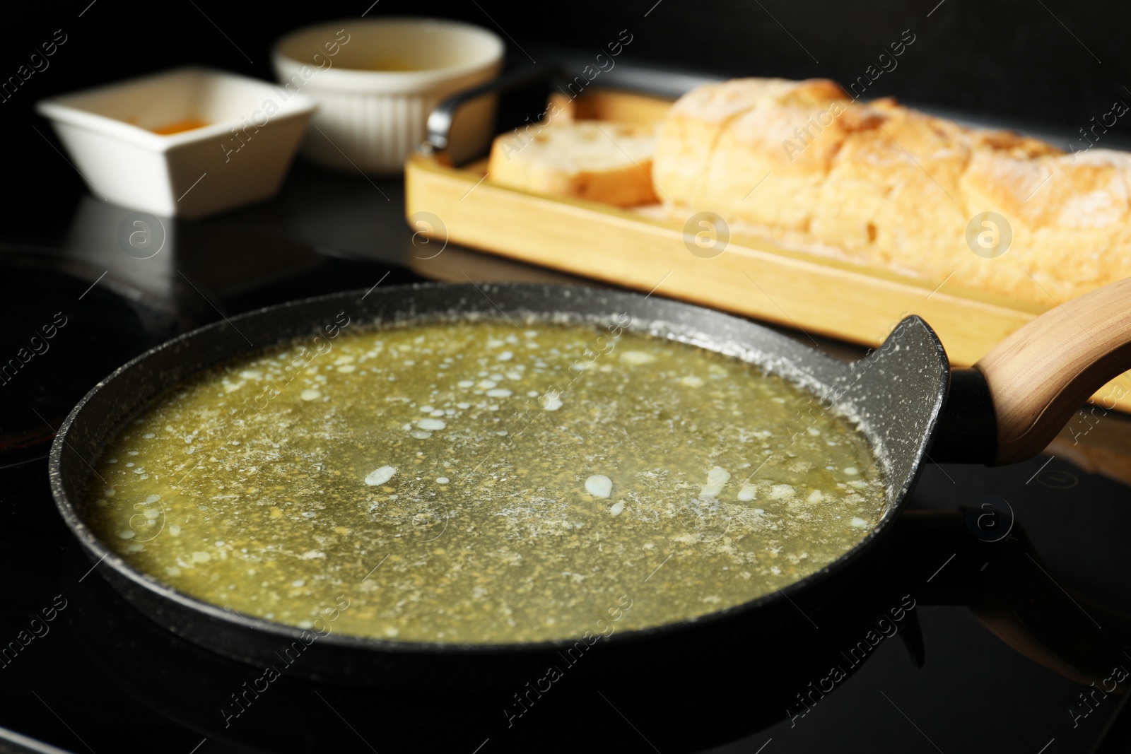 Photo of Melted butter in frying pan on cooktop, closeup