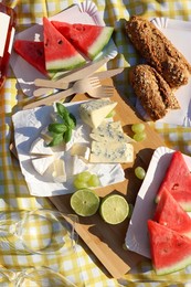 Photo of Delicious food and wine on picnic blanket, above view