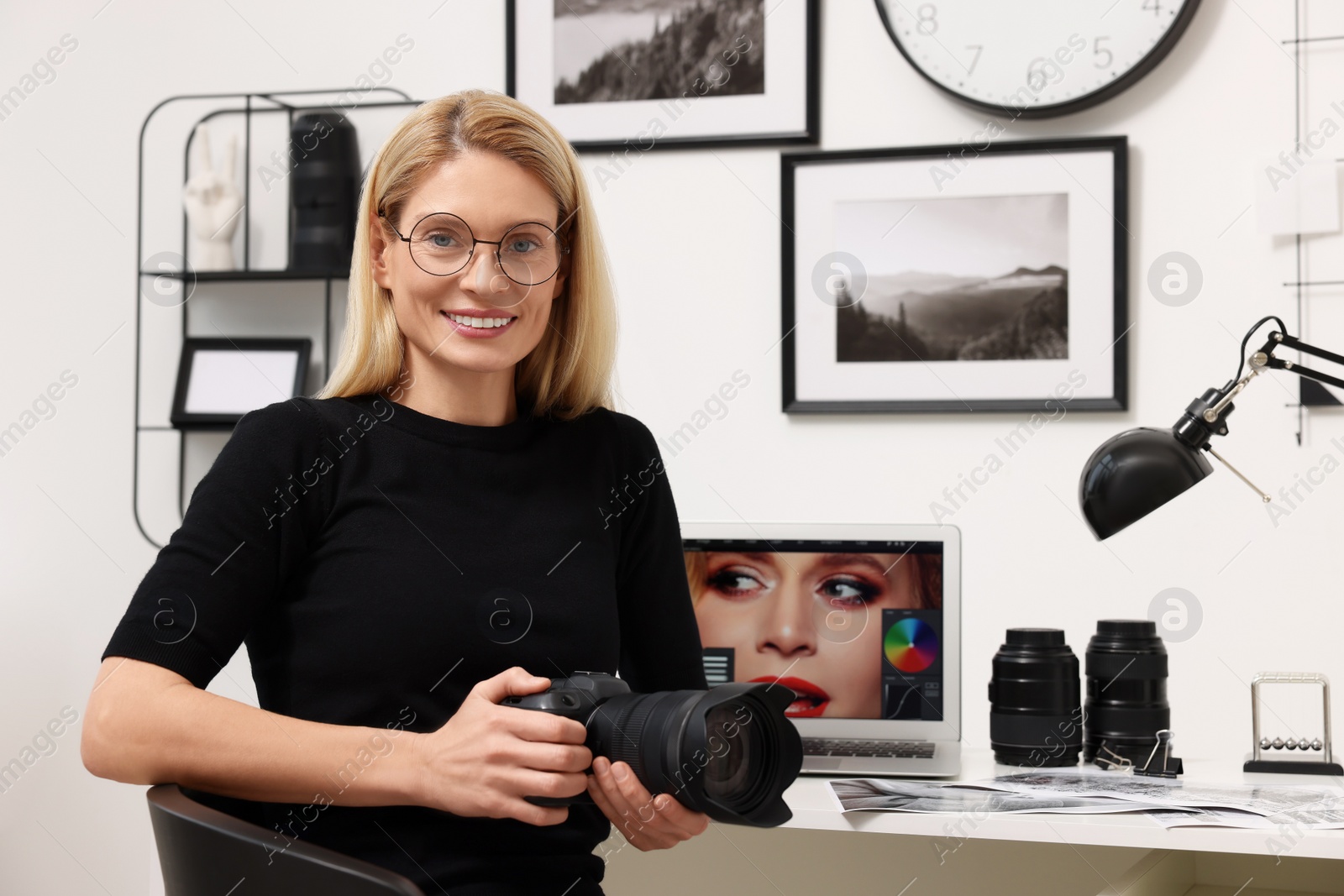 Photo of Professional photographer with digital camera at table in office