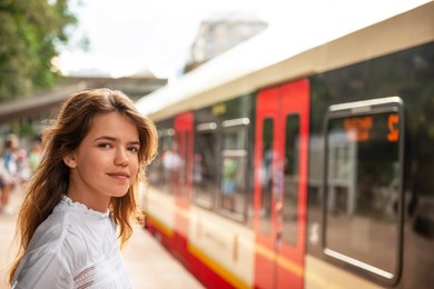 Teenage girl at train stop, space for text