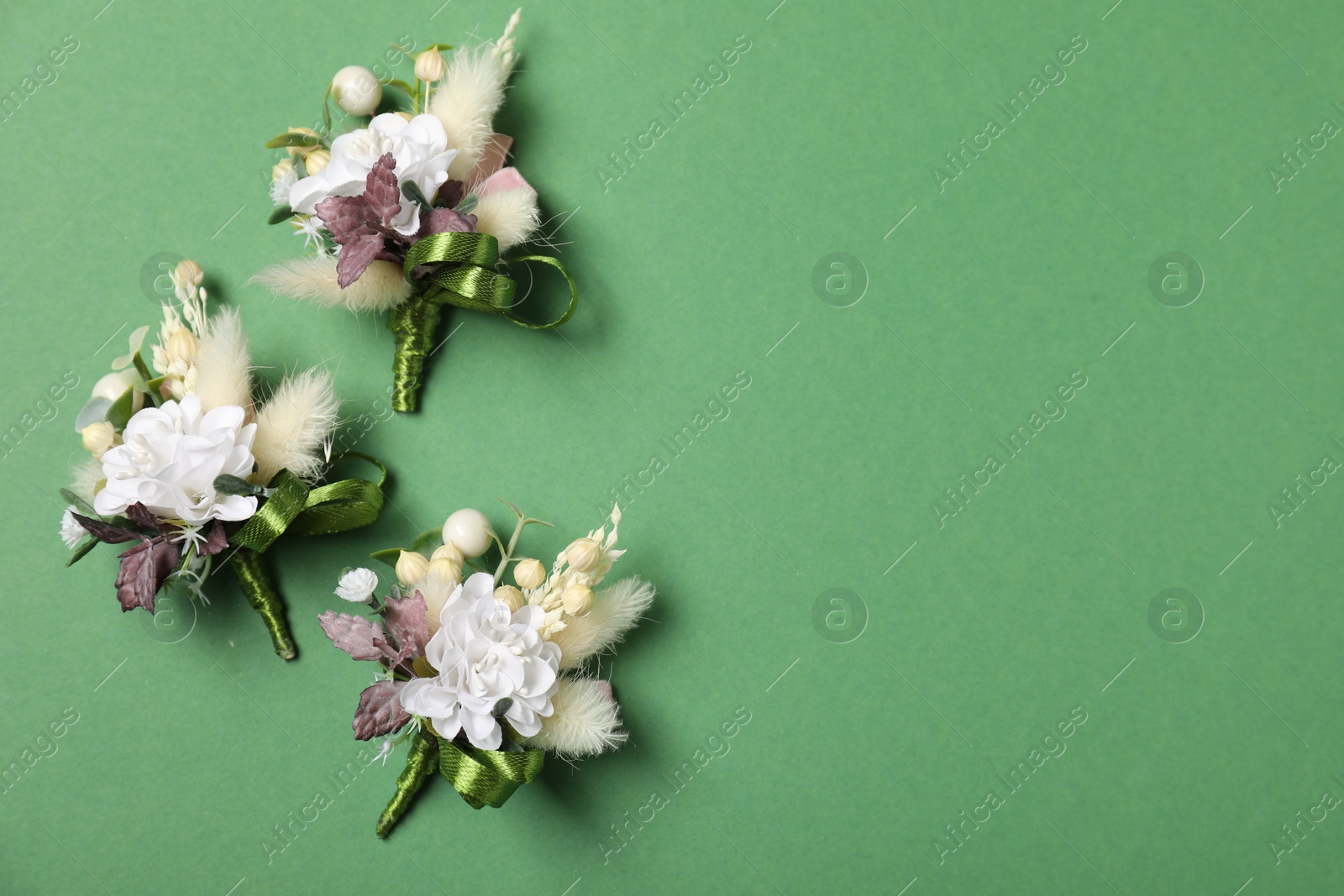 Photo of Stylish boutonniere on green background, flat lay. Space for text
