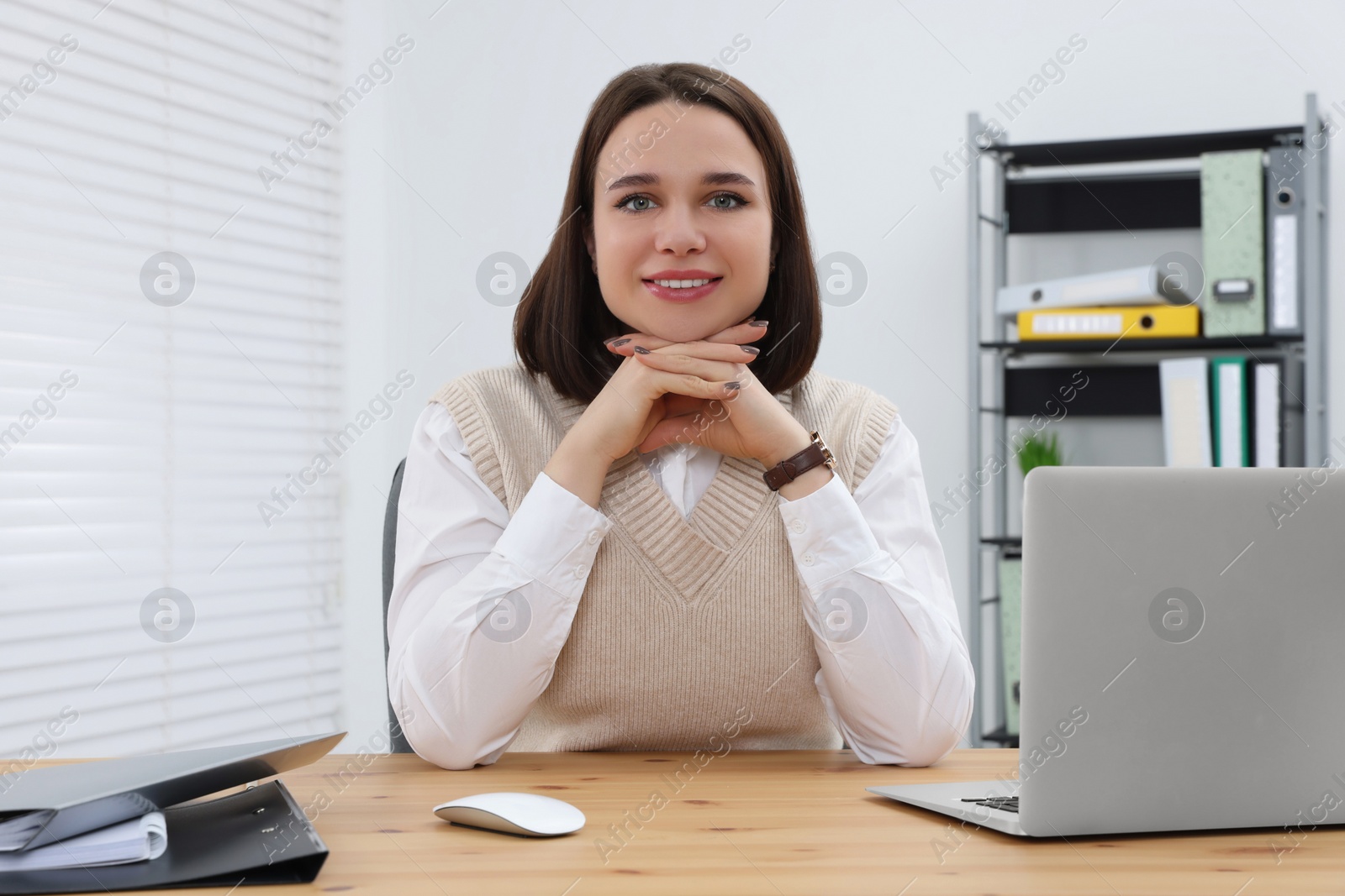 Photo of Happy young intern working at table in modern office