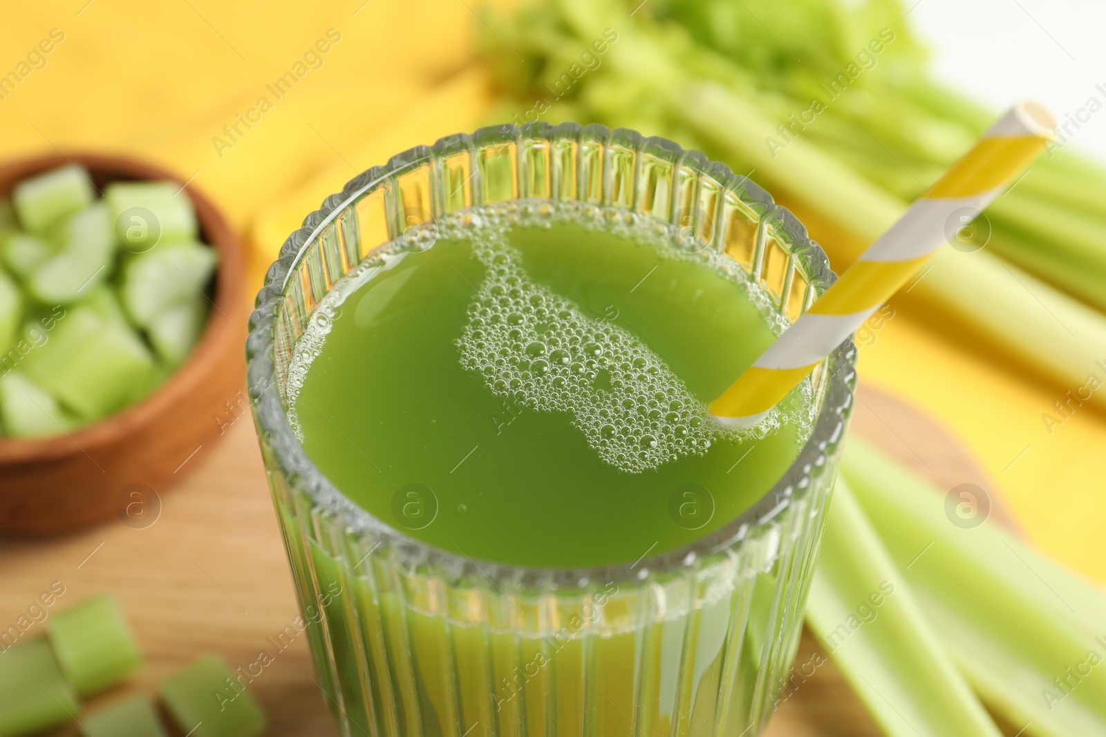Photo of Glass of delicious celery juice and vegetables on wooden board, closeup