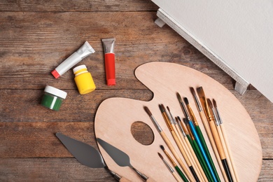 Photo of Set of painting tools for children on wooden background, top view