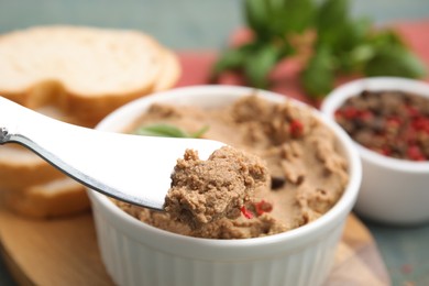 Delicious meat pate with spices and knife on wooden board, closeup