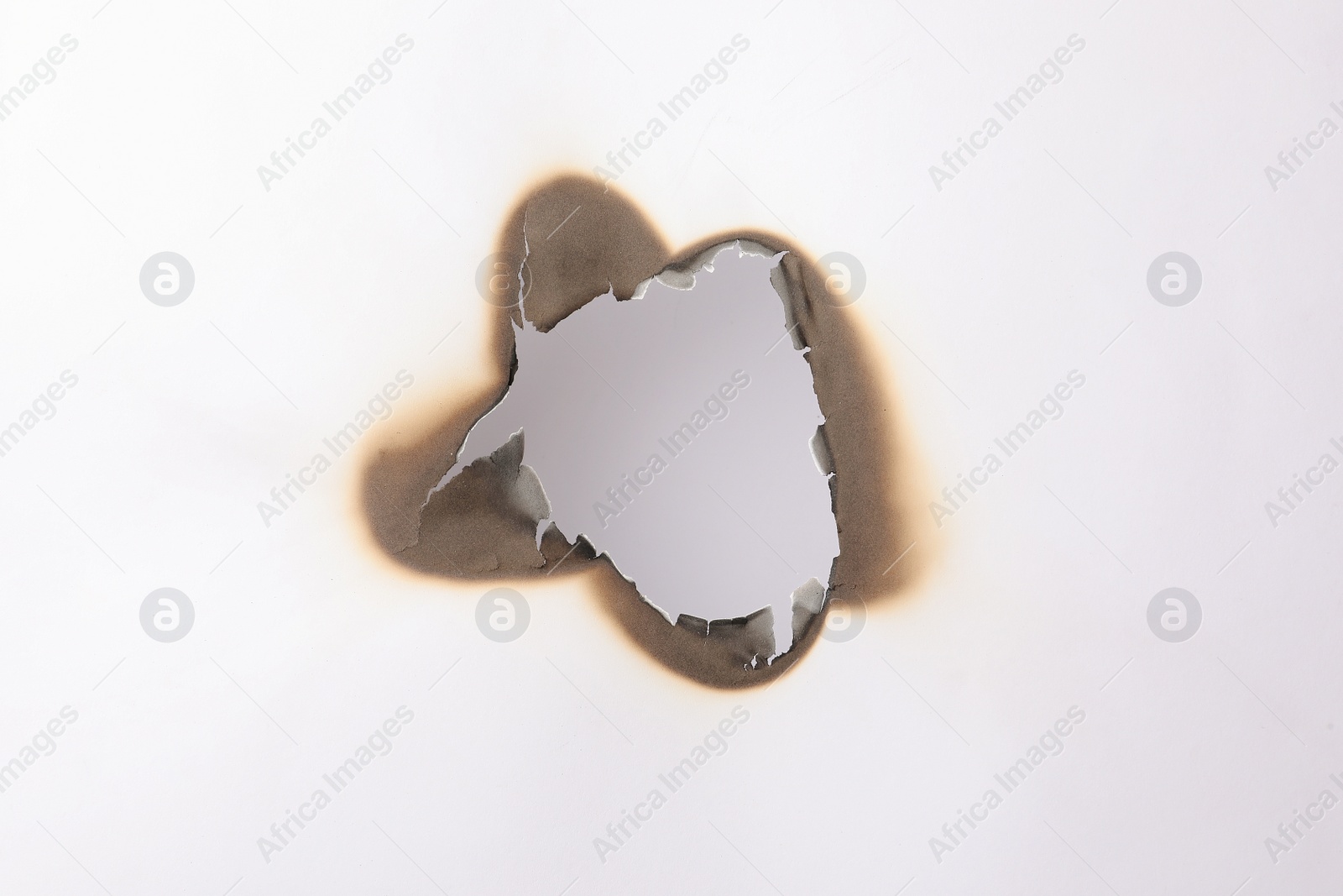 Photo of Burnt hole in paper on white background