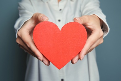 Woman holding red heart, closeup