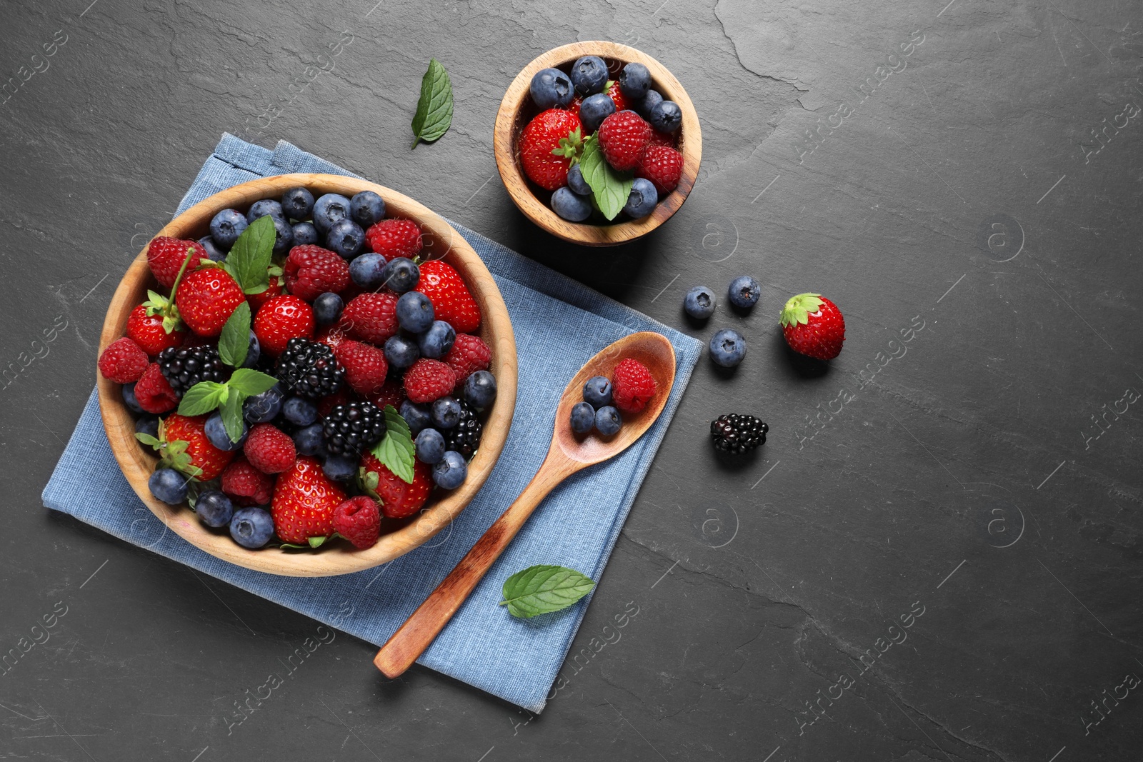 Photo of Many different fresh ripe berries on black table, flat lay. Space for text