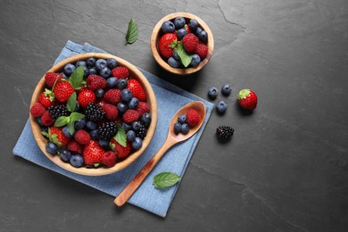 Many different fresh ripe berries on black table, flat lay. Space for text