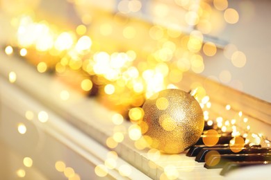 Image of Christmas and New Year music. Piano with festive ball, bokeh effect