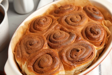 Baking dish with cinnamon rolls on table, closeup