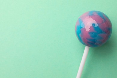 Photo of Tasty lollipop on turquoise background, top view. Space for text