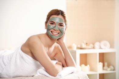 Photo of Beautiful woman with mask on face relaxing in spa salon. Space for text