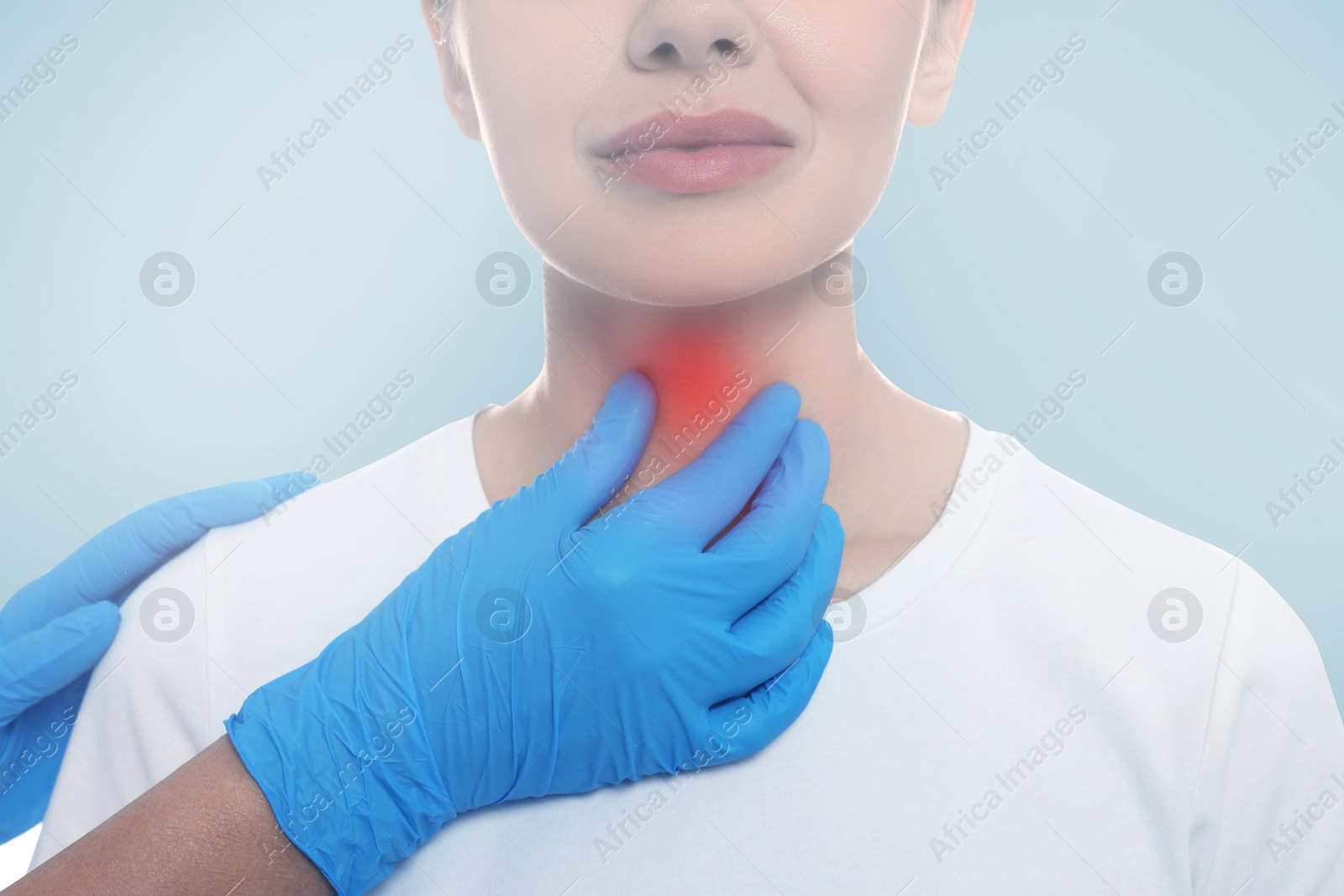 Image of Endocrinologist examining thyroid gland of patient on light blue background, closeup