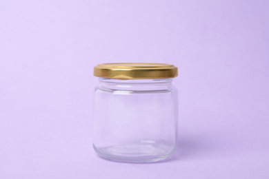 Photo of Closed empty glass jar on lilac background