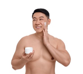 Handsome man applying cream onto his face on white background