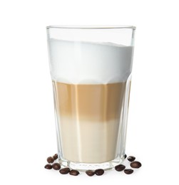 Glass of delicious latte macchiato and scattered coffee beans on white background
