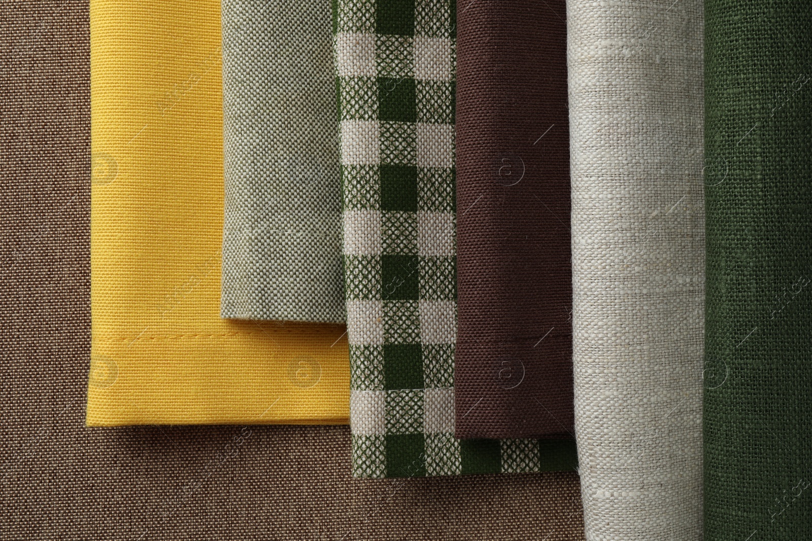 Photo of Many different fabrics on brown cloth, top view