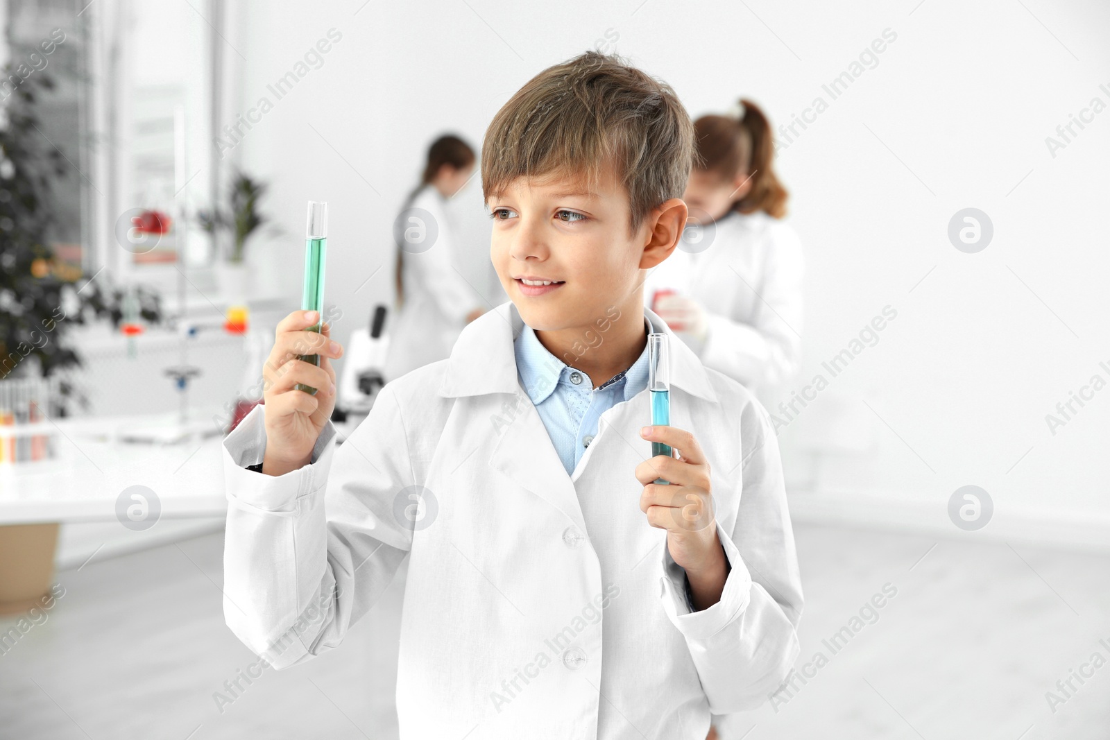Photo of Smart pupil with test tubes at chemistry class