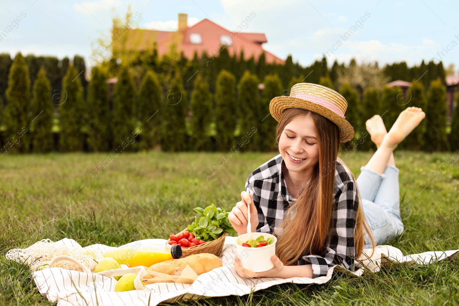 Photo of Happy girl having picnic on green grass in park