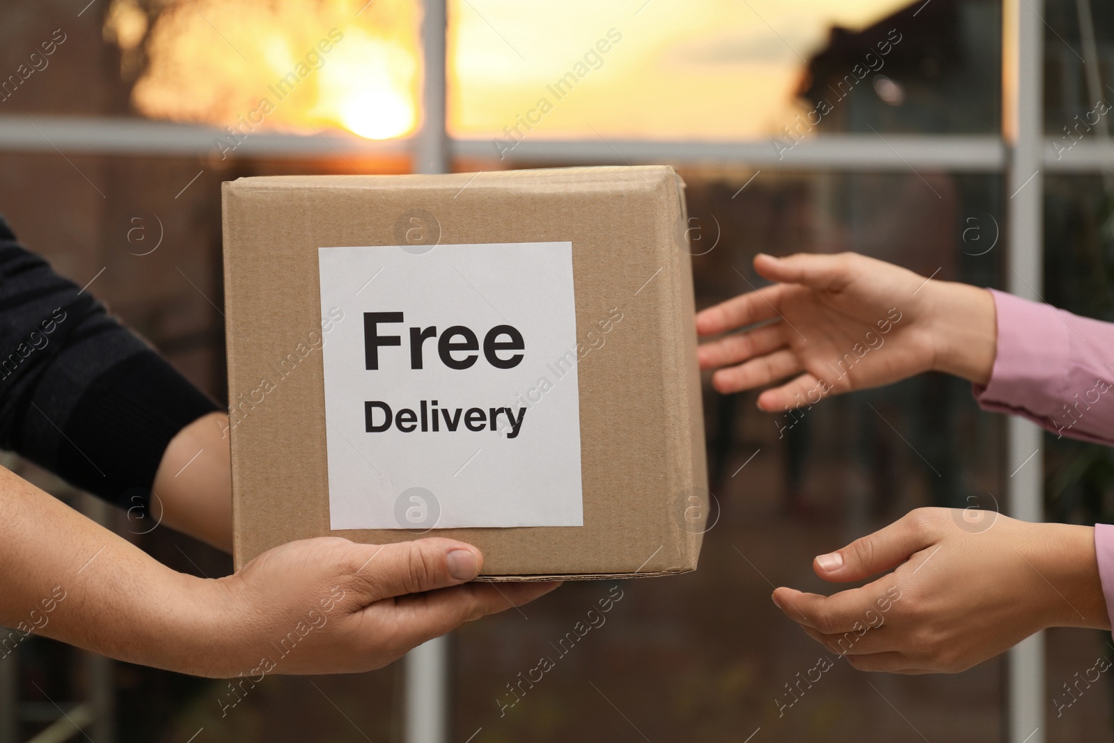 Photo of Woman receiving parcel with sticker Free Delivery from courier indoors, closeup