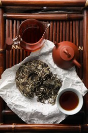 Photo of Flat lay composition with pu-erh tea on wooden tray. Traditional ceremony