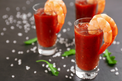 Photo of Delicious shrimp cocktail with tomato sauce served on black table