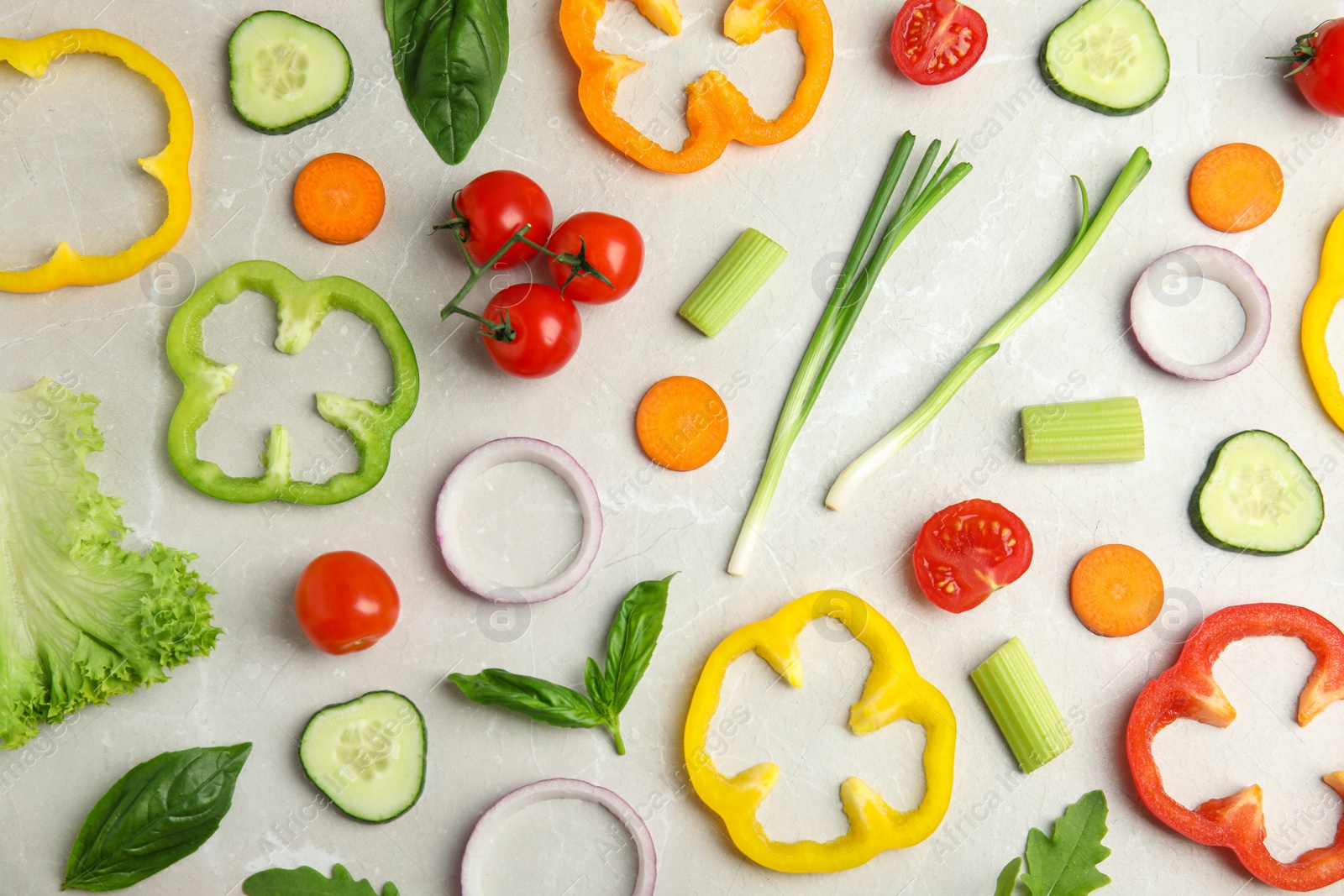 Photo of Flat lay composition with fresh ingredients for salad on light table