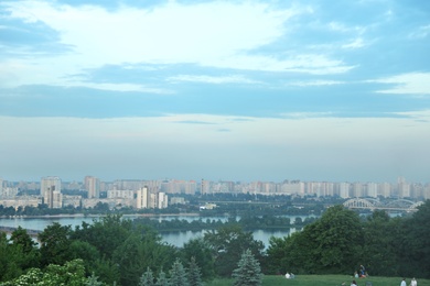Photo of KYIV, UKRAINE - MAY 23, 2019: Beautiful cityscape with green park and Darnitsky railway bridge