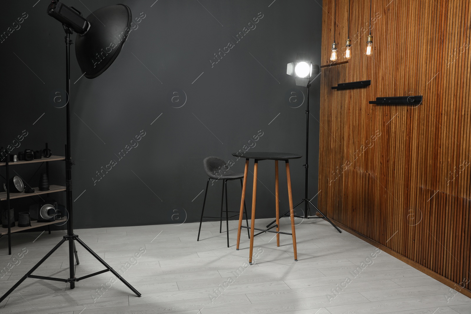 Photo of Empty table with chair and professional equipment in photographer's studio