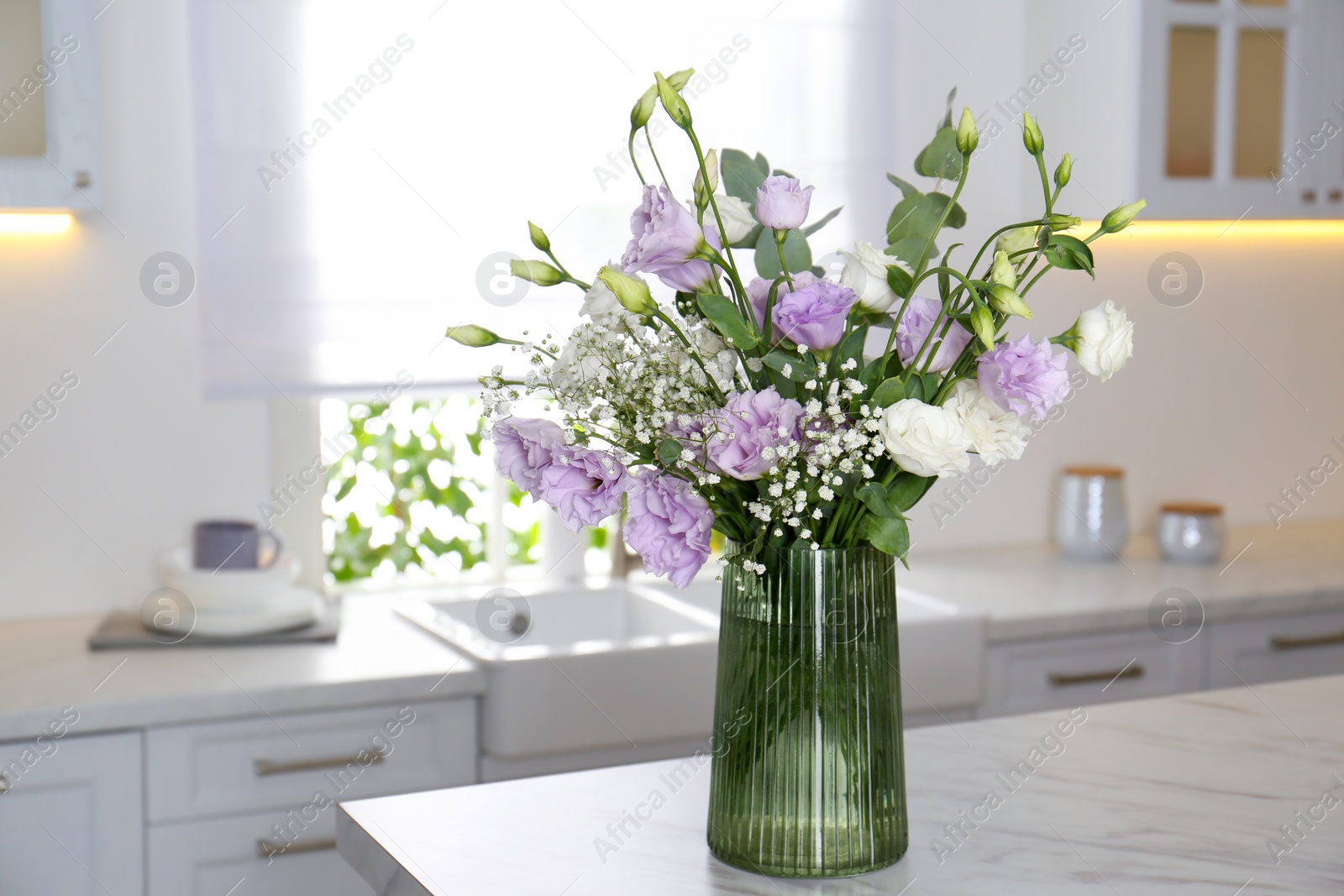 Photo of Beautiful bouquet with Eustoma flowers on table in kitchen