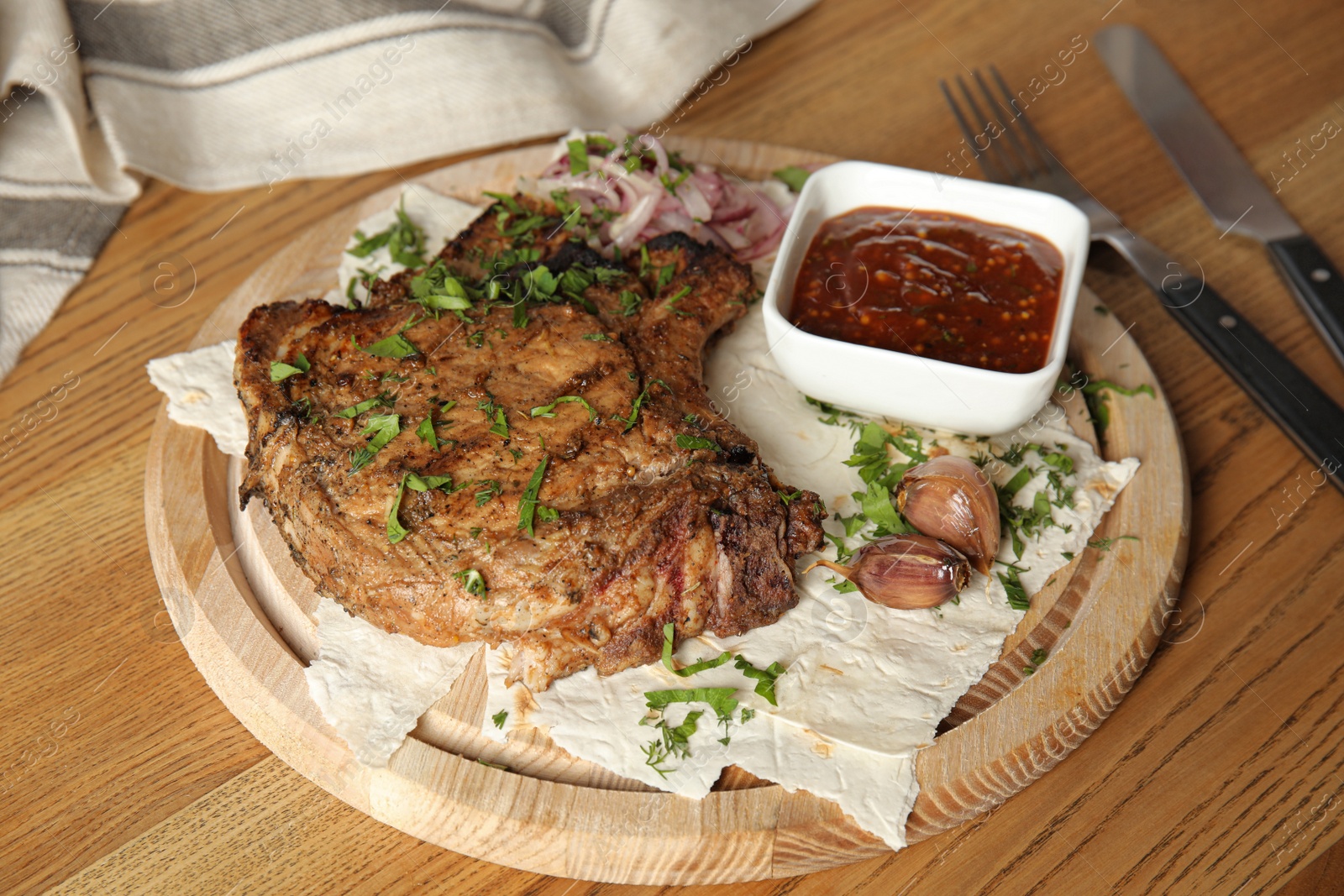 Photo of Delicious grilled pork chop served on wooden table