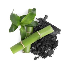 Photo of Fresh bamboo and charcoal on white background, top view