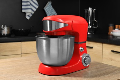 Photo of Modern stand mixer on wooden table in kitchen