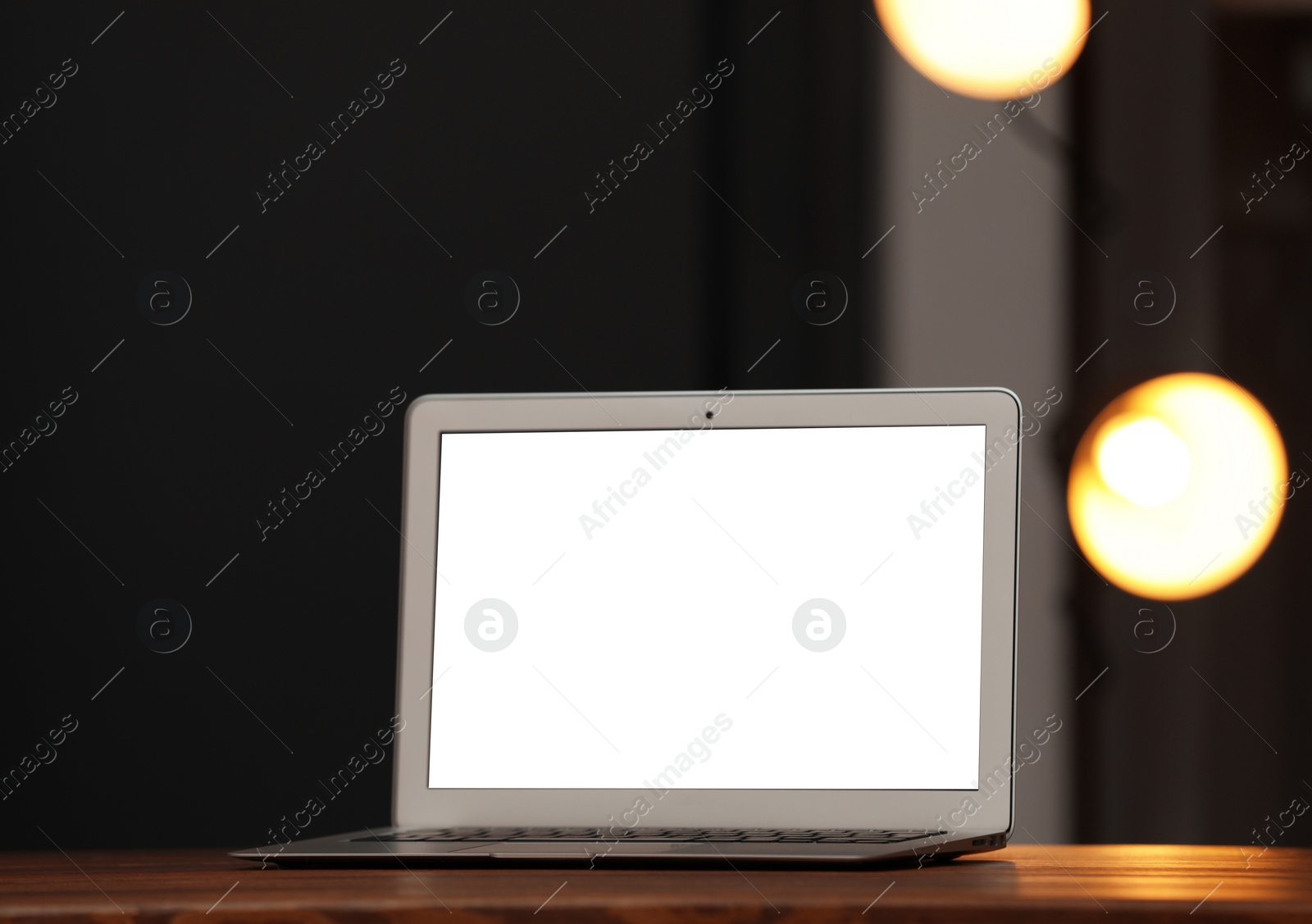 Photo of Laptop with blank screen on table indoors. Space for text