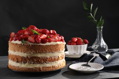 Tasty cake with fresh strawberries and mint served on gray table