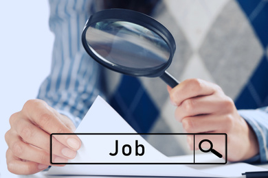 Woman using magnifying glass at table, closeup. Job search