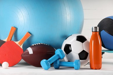 Photo of Many different sports equipment on white table