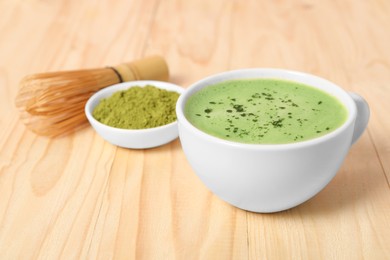 Photo of Cup of tasty matcha latte on wooden table, closeup. Space for text