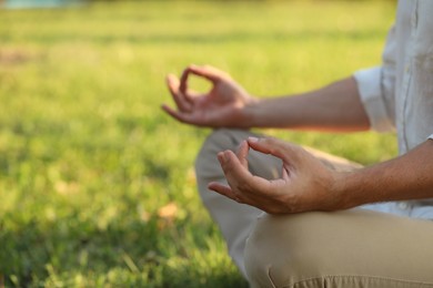 Photo of Man meditating outdoors on sunny day, closeup. Space for text