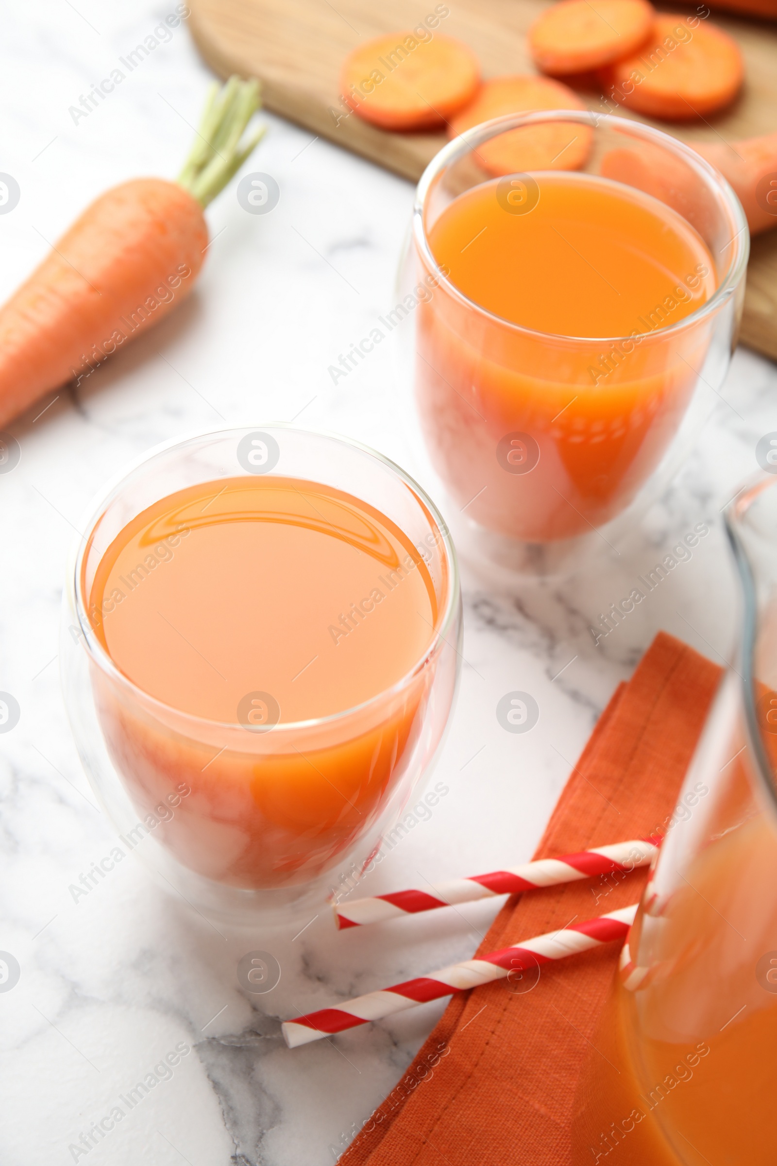 Photo of Freshly made carrot juice on white marble table