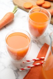 Photo of Freshly made carrot juice on white marble table