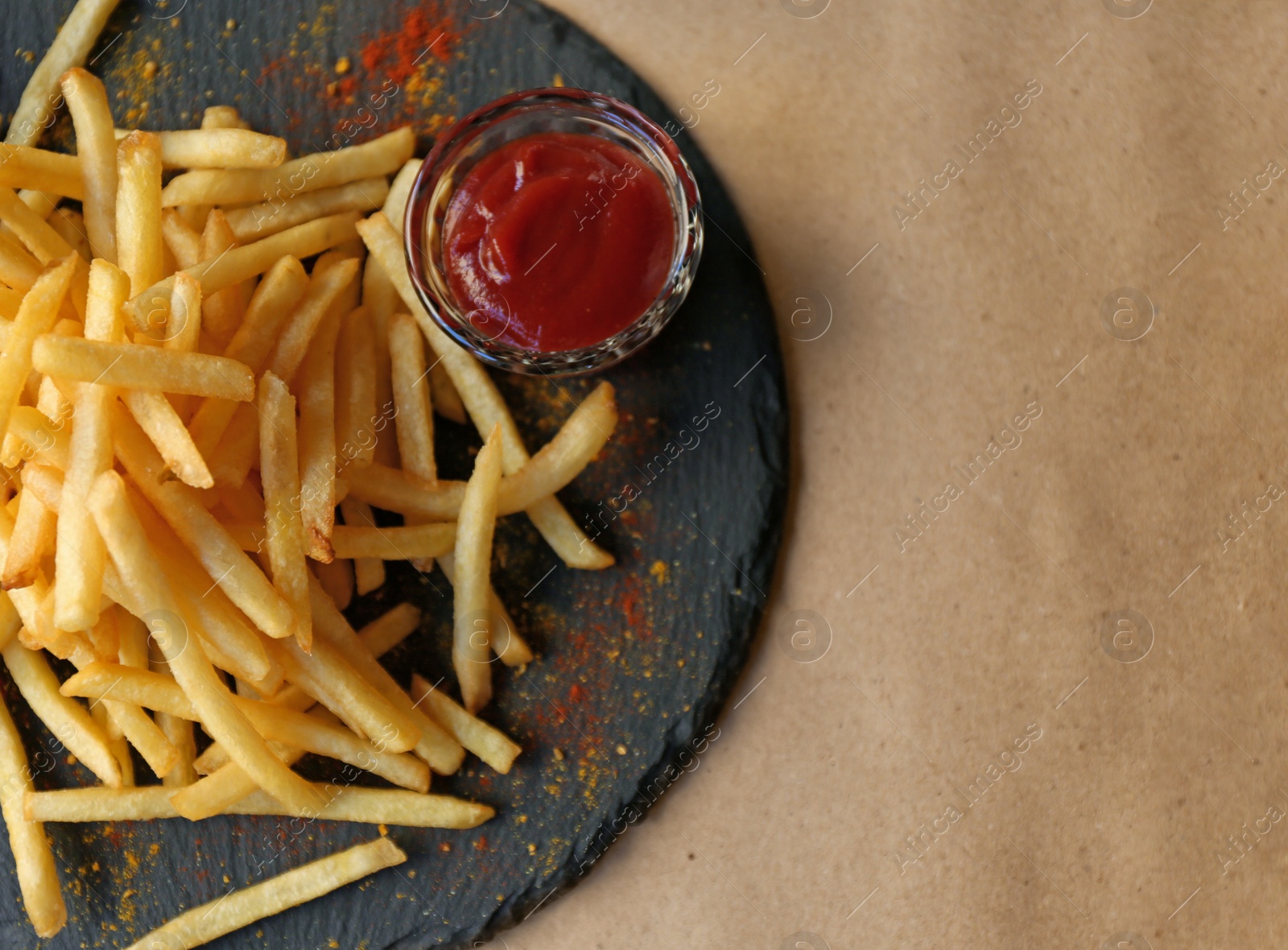 Photo of Tasty French fries with red sauce served on table in cafe, top view. Space for text