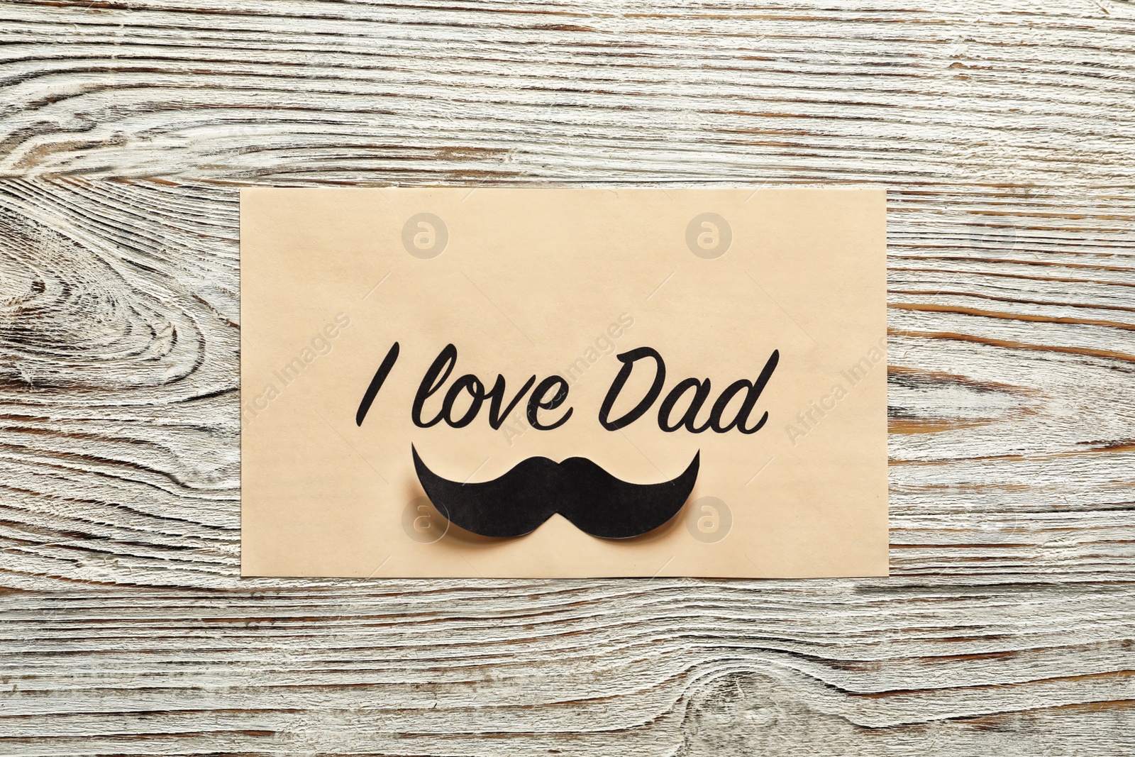 Photo of Card with words I LOVE DAD on wooden background, top view. Father's day celebration