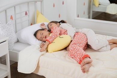 Cute girls in pajamas sleeping at home