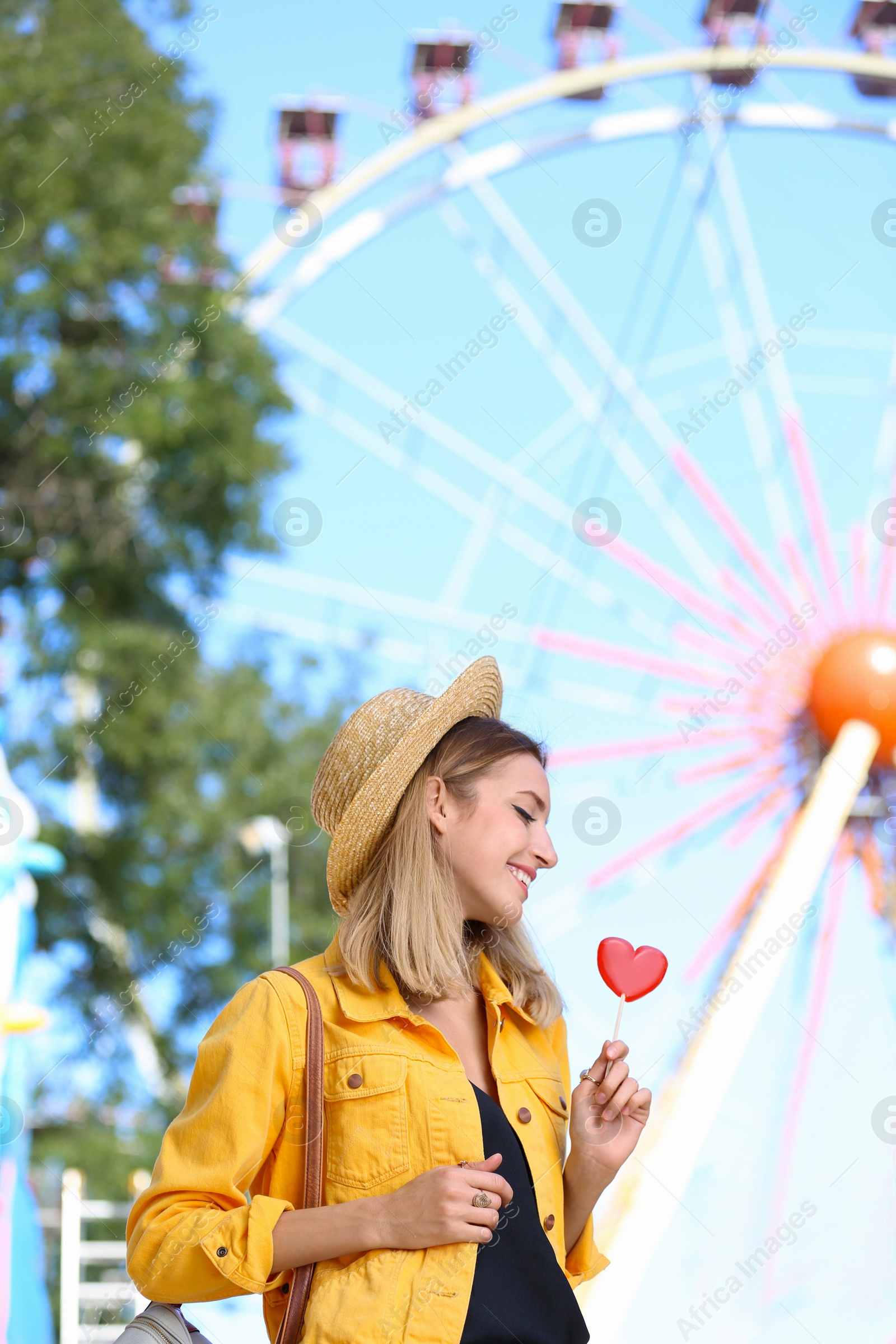 Photo of Beautiful woman with candy having fun at amusement park