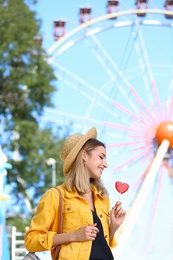 Beautiful woman with candy having fun at amusement park