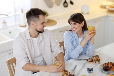 Photo of Happy couple having tasty breakfast at home