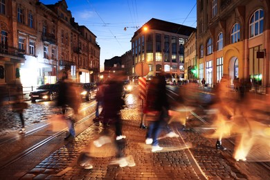 Photo of People crossing city street at night, long exposure effect